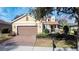 Well-maintained house with a brown garage door and brick driveway at 107 Cupania Ct, Groveland, FL 34736