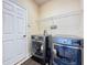 Convenient laundry room with washer, dryer, and ample storage at 107 Cupania Ct, Groveland, FL 34736