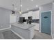 Bright kitchen with a gray center island, stainless steel appliances, and modern pendant lighting above the countertop at 11526 Comic Aly, Orlando, FL 32832