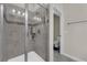 Contemporary shower with gray tiling, glass enclosure, built-in shelving and modern fixtures at 11526 Comic Aly, Orlando, FL 32832