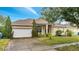 Attractive single-story home with a two-car garage and well-manicured lawn at 116 Whispering Pines Way, Davenport, FL 33837