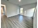 Well-lit bedroom with gray vinyl plank flooring and access to the hallway at 1212 Baltic Dr Way, Poinciana, FL 34759