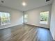 Spacious bedroom with gray vinyl plank flooring and large windows offering natural light at 1212 Baltic Dr Way, Poinciana, FL 34759