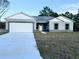 Newly constructed home with a two-car garage and a landscaped yard at 1212 Baltic Dr Way, Poinciana, FL 34759