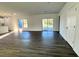 Bright living room features gray vinyl plank flooring and sliding glass doors to the backyard at 1212 Baltic Dr Way, Poinciana, FL 34759