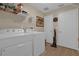 Laundry room with Whirlpool washer and dryer, and ample shelving at 13013 Quail Ct, Orlando, FL 32828