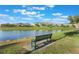 Peaceful lakefront park with a green bench and beautiful landscaping at 13715 Bressler Aly, Windermere, FL 34786