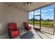 Relaxing screened porch with two red chairs and view of backyard at 13715 Bressler Aly, Windermere, FL 34786