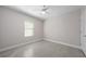 Bright bedroom with light-colored walls, ceiling fan, window, and tile flooring at 1470 Silverado Flats St, Kissimmee, FL 34744