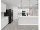 Modern kitchen featuring white cabinets, sleek black appliances, and an island with pendant lighting at 1470 Silverado Flats St, Kissimmee, FL 34744