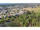 Aerial view showcasing a lakefront community with lush greenery and homes at 15925 St Clair St, Clermont, FL 34714