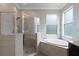 Bathroom with shower and oval soaking tub, featuring neutral tile at 15925 St Clair St, Clermont, FL 34714