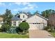 Two-story house with a beige exterior, gray roof, and a two-car garage at 15925 St Clair St, Clermont, FL 34714