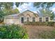 Tan house with a gray roof, two-car garage, and landscaped front yard at 1603 S Mary St, Eustis, FL 32726