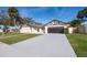 Updated home exterior featuring a large driveway and manicured lawn at 2247 King Edwards Ct, Winter Park, FL 32792