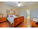 Spacious bedroom with wood floors, a wooden sleigh bed, and access to a bathroom at 2446 Leaning Pine Ln, Oviedo, FL 32765