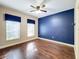 Bright bedroom with dark blue accent wall and hardwood floors at 2511 Madron Ct, Orlando, FL 32806