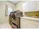 Bright laundry room with washer, dryer, and cabinets at 2511 Madron Ct, Orlando, FL 32806