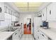 White kitchen with stainless steel appliances and view into dining area at 2823 Cady Way, Winter Park, FL 32792