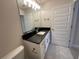 Bathroom with dark granite vanity and neutral tile floor at 3019 Tackle Drive, Leesburg, FL 34748