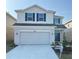 Two-story house with white siding, gray garage door, and landscaping at 3019 Tackle Drive, Leesburg, FL 34748