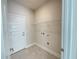 Laundry room with wire shelving and neutral tile flooring at 3019 Tackle Drive, Leesburg, FL 34748