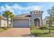 One-story home with gray exterior, brick driveway and landscaping at 308 Vestrella Dr, Kissimmee, FL 34759