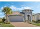 Gray house with a two-car garage and nicely landscaped yard at 308 Vestrella Dr, Kissimmee, FL 34759