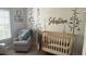 Charming Bedroom with crib, rocking chair, and woodland wall decor at 3663 Lomond Ct, Apopka, FL 32712