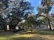 Side view of house with mature trees and landscaping at 3663 Lomond Ct, Apopka, FL 32712