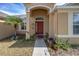 Tan house with red door, two-car garage, and landscaped yard at 405 Kehoe Blvd, Orlando, FL 32825