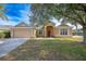 Tan house exterior with red door and attached garage at 405 Kehoe Blvd, Orlando, FL 32825