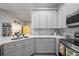 Modern kitchen with gray cabinets, quartz countertops, and stainless steel appliances at 405 Kehoe Blvd, Orlando, FL 32825