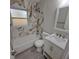 Renovated bathroom with marble-look tile, bathtub and modern vanity at 4220 Lancashire Ln, Orlando, FL 32812