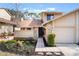 Tan two-story townhome with a paved walkway, landscaping, and attached garage at 447 Stanton Pl, Longwood, FL 32779