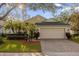 One-story house with a two-car garage and landscaped front yard at 452 Misty Oaks Run, Casselberry, FL 32707