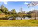 Scenic pond view with lush landscaping and reflection of homes at 452 Misty Oaks Run, Casselberry, FL 32707