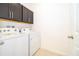 Bright laundry room with washer, dryer, and upper cabinets at 4767 Cragmere Loop, Clermont, FL 34711