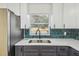 Modern kitchen features stainless steel appliances and teal tile backsplash at 5216 Bonnie Brae Cir, Orlando, FL 32808