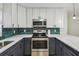 Modern kitchen featuring white and dark gray cabinets, and green tile backsplash at 5216 Bonnie Brae Cir, Orlando, FL 32808