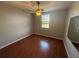 Bright bedroom with wood floors, ceiling fan, and large window at 5550 E Michigan St # 2223, Orlando, FL 32822