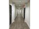 Long condo hallway with gray doors and wood floors at 5550 E Michigan St # 2223, Orlando, FL 32822