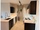 Modern kitchen with dark cabinets, white countertops, and stainless steel appliances at 5550 E Michigan St # 2223, Orlando, FL 32822