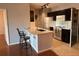 Modern kitchen with breakfast bar, dark cabinets, and white countertops at 5550 E Michigan St # 2223, Orlando, FL 32822