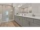 Modern main bathroom with a double vanity, gray cabinets, and a glass-enclosed shower at 558 Pawnee Ct, Haines City, FL 33844