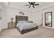 Beautifully staged main bedroom featuring a tray ceiling, carpeted floors, and ensuite bathroom at 558 Pawnee Ct, Haines City, FL 33844