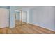 Light blue bedroom with mirrored closet and wood flooring at 706 Santa Cruz Ln, Howey In The Hills, FL 34737