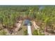 Aerial view of a grey home nestled among tall pine trees on a large lot at 7542 Sw 128 Terrace Rd, Dunnellon, FL 34432