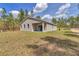 View of home's rear featuring a sliding glass door, patio, and a expansive lawn at 7542 Sw 128 Terrace Rd, Dunnellon, FL 34432