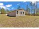 Back of the property shows a large, grassy yard surrounded by trees at 7542 Sw 128 Terrace Rd, Dunnellon, FL 34432
